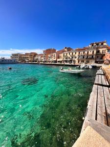 a boat in a body of water with buildings at Regina di Cuori in La Maddalena