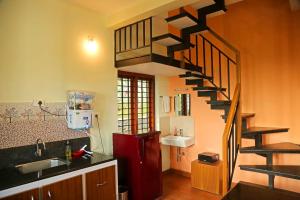 a kitchen with a spiral staircase in a kitchen at Karapuzha Water Scapes Wayanad in Wayanad