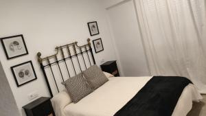 a bedroom with a bed with a black blanket on it at Apartamento Zafra Jaime in Zafra