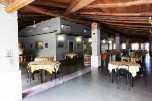 a dining room with tables and chairs and wooden ceilings at Funny Village Dog Friendly in Pizzo