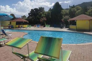 a swimming pool with chairs and a swimming pool at Funny Village Dog Friendly in Pizzo