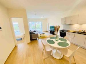 Una cocina y una sala de estar con mesa y sillas. en Luxury Flat in city center with free parking-HOL1, en Luxemburgo 3 fotos más