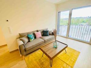 una sala de estar con un sofá y una mesa en Luxury Flat in city center with free parking-HOL1, en Luxemburgo