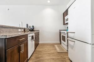 a kitchen with wooden floors and a white refrigerator at Entire High-Rise Apartment - 2BD in Baton Rouge