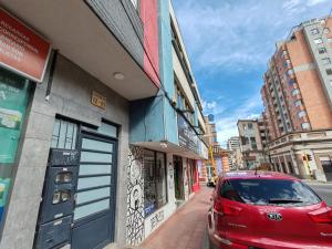 a red car parked in front of a building at Acogedor apartamento en el corazón de Duitama in Duitama
