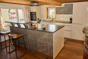 a kitchen with a large counter with stools at Ferienhaus Luisa in Bad Ragaz