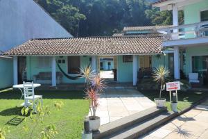 a house with a sign in front of it at Pousada do Contorno in Angra dos Reis