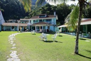 a group of white chairs in the yard of a house at Pousada do Contorno in Angra dos Reis