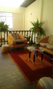 a living room with couches and a table at Casa de Huespedes Isabella in Sucre
