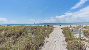 a path to a beach with a sign on it at Beach Haven in Longboat Key