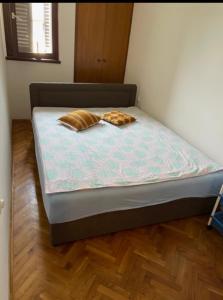 a bed with two pillows on it in a room at Palma Baosici in Baošići +8 photos