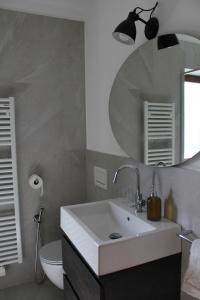 a bathroom with a white sink and a mirror at Residence Lärchenhäusl in Soprabolzano +47 photos