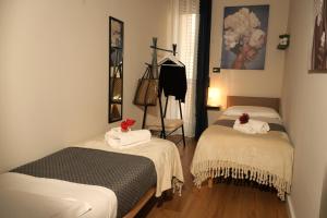 a room with two beds with towels on them at Tiffany Home in Matera