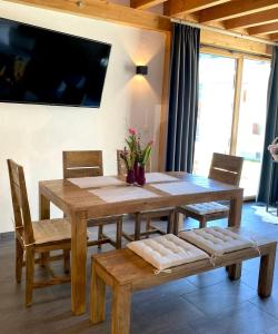 a wooden dining room table with chairs and a television at Mountain Apart Katzenkopf in Leutasch