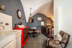 a kitchen with a red counter and a table and a clock at Studio Raguso in Martina Franca