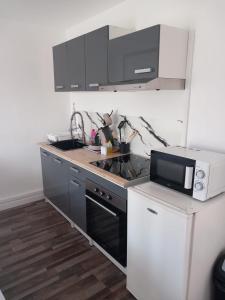 a kitchen with a sink and a microwave at White and Cotton Suite in Saint-Paul-de-Fenouillet +20 photos