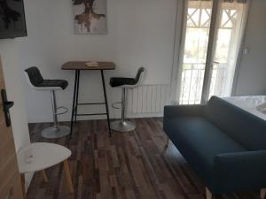 a living room with a couch and a table and chairs at White and Cotton Suite in Saint-Paul-de-Fenouillet