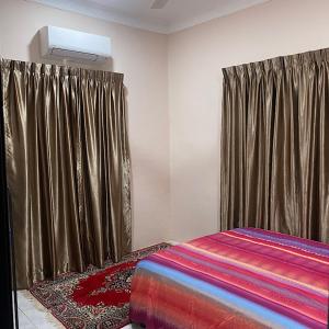 Gua SaiにあるDarainhomestayのベッドルーム1室(カーテンとラグ付きのベッド1台付)