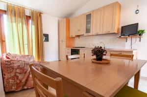 une cuisine et une salle à manger avec une table en bois dans l'établissement Appartamento Valentina Caletta sul mare, à La Caletta 6 autres photos