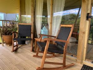 two rocking chairs sitting on a porch at Tregantle Farm Eco GLAMPSITE in Torpoint