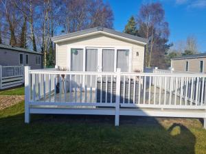a white fence in front of a house at Golf and Leisure Retreat in Great Yarmouth