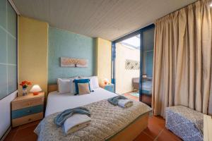 een slaapkamer met een bed en een groot raam bij Blue Marine 1 VIP Barbati On The Beach - Public Pool in Barbati