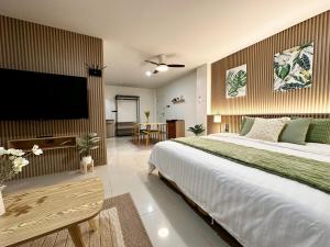 a bedroom with a large bed and a flat screen tv at Serene Escape 2 mins from SRT Wat Samien Nari in Bangkok