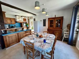 cocina con mesa con sillas y mantel en Charming seaside family home - sleeps 8, en Saint-Michel-en-Grève