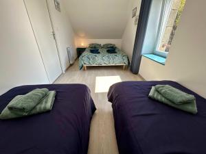 2 camas en una habitación pequeña con 1 dormitorio en Charming seaside family home - sleeps 8, en Saint-Michel-en-Grève