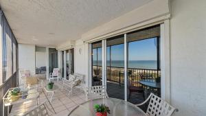 a balcony with a table and chairs and the ocean at Gulf View Escape in Siesta Key