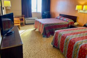 una camera d'albergo con due letti e una televisione di Red Carpet Inn & Suites Lima -Listing Partner a Lima
