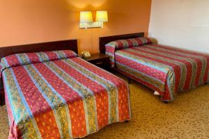 Letto o letti in una camera di Red Carpet Inn & Suites Lima -Listing Partner