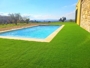 une piscine au milieu d'une pelouse verdoyante dans l'établissement Gîte de charme L'Escale Des Sens sauna et jacuzzi privé sud Ardéche, à Bessas 6 autres photos