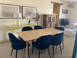 a dining room with a wooden table and blue chairs at El encanto de un pueblo in Grajal de Campos