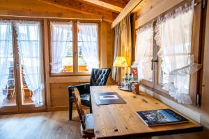 a wooden table in a room with windows at Posthotel Rössli in Gstaad