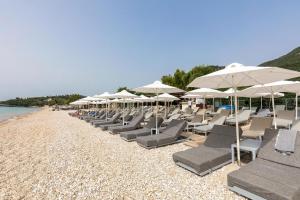 een rij ligstoelen en parasols op een strand bij Blue Marine 1 VIP Barbati On The Beach - Public Pool in Barbati