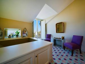 Habitación con 2 sillas moradas y mesa. en Villa Gialisa, en Sorrento