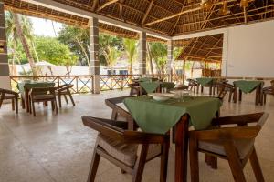 un restaurante con mesas y sillas con mantel verde en The Soul Zanzibar Beach Hotel & Spa, en Pwani Mchangani Mdogo