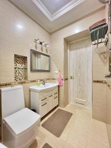 a bathroom with a white toilet and a sink at Nordic Style Apartment in Fergana +20 photos