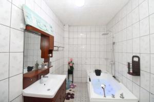 a bathroom with a tub and a sink and a bath tub at RJS Appart Homey1 avec Jacuzzi in Douala +1 photo