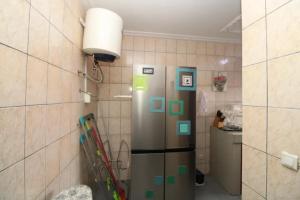 a kitchen with a refrigerator with green magnets on it at RJS Appart Homey1 avec Jacuzzi in Douala
