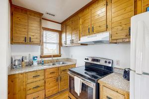a kitchen with wooden cabinets and a stove top oven at Tarpon Drive Hideaway Unit B in Avon