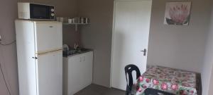 a kitchen with a refrigerator and a table and a microwave at Taylor's Nest in Mancana +4 photos