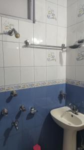 a blue and white tiled bathroom with a sink at Kinley Homestay in Darjeeling
