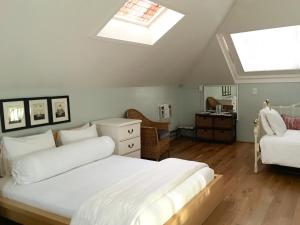 a bedroom with a large white bed and a skylight at Cowper Inn in Palo Alto