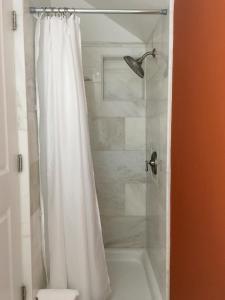 a shower with a white shower curtain in a bathroom at Cowper Inn in Palo Alto