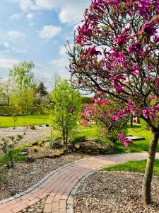 a tree with pink flowers on a brick walkway at Ferienwohnungen Maedchen in Wunstorf