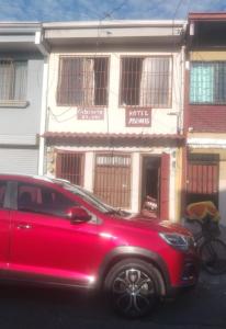 a red car parked in front of a building at Playa ,sol y arena in Puntarenas