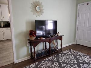 a living room with a television on a table at Sage Street Cottage in Winnsboro