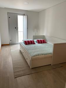 a bedroom with a bed with red pillows on it at Apartamento Duplex - Beach Apart in Vila Praia de Âncora +7 photos